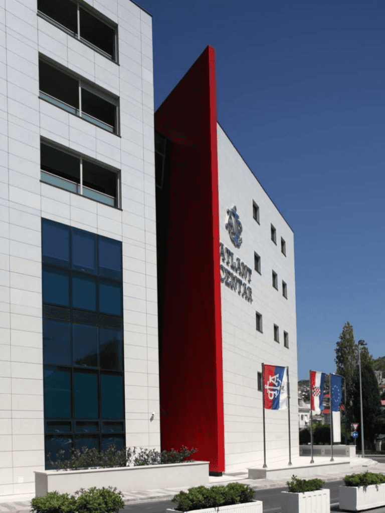 Modern Police Station building with flags in Croatia, clean exterior, sunny day, official government facility.