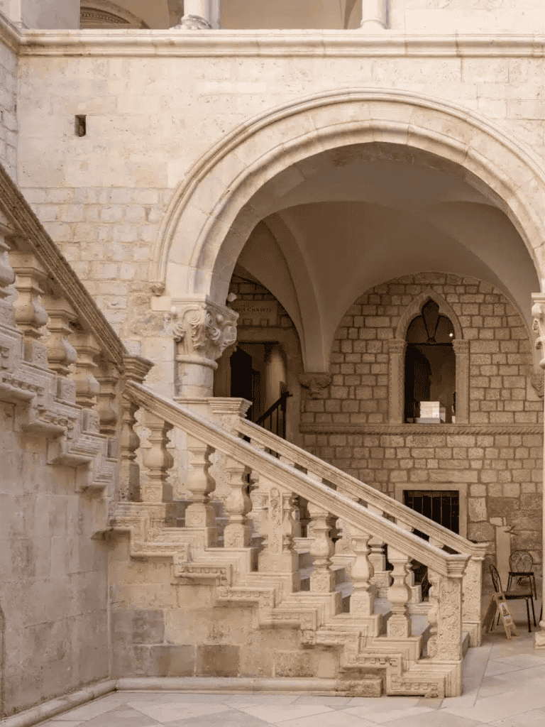Luxury stone staircase with ornate balustrades in historic building.