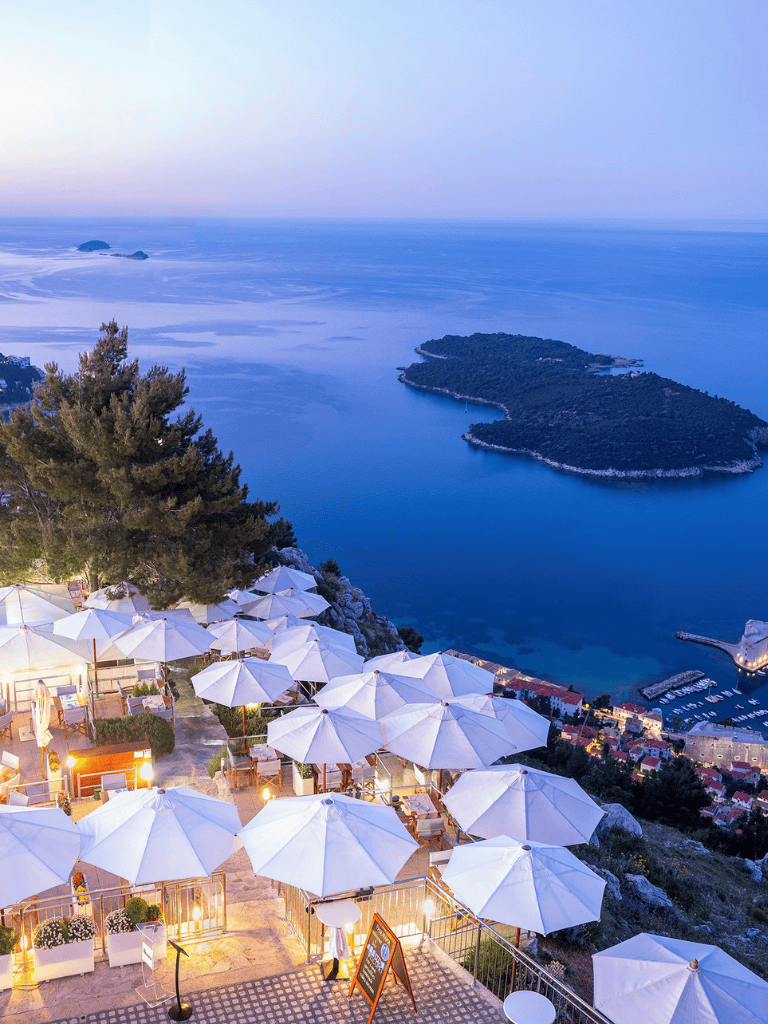 Breathtaking coastal landscape with dining terrace overlooking the sea and scenic island view.