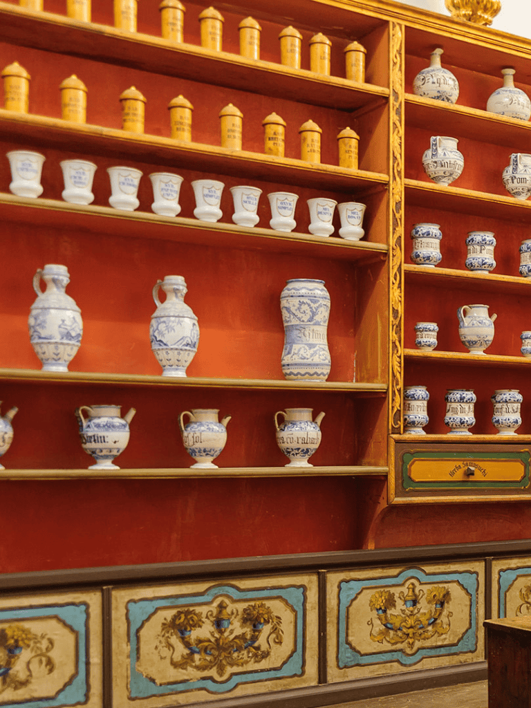 Delicate blue and white antique pottery displayed on wooden shelves, showcasing traditional ceramic craftsmanship.