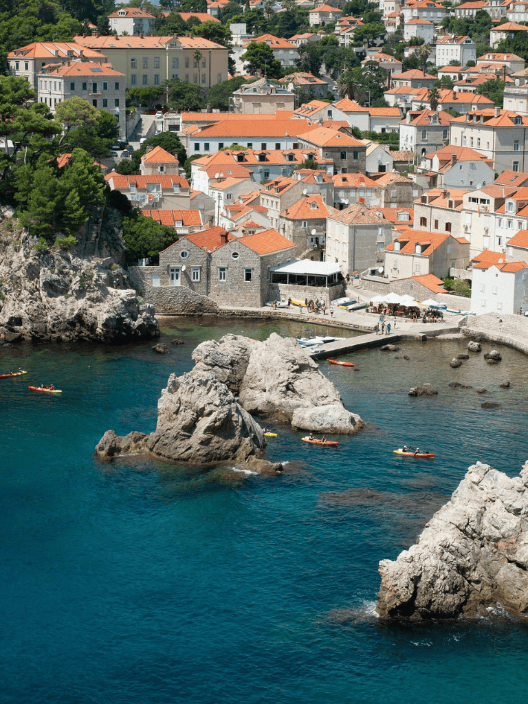 Colorful coastal town with red-tiled roofs and clear blue waters, perfect for scenic views and seaside activities.