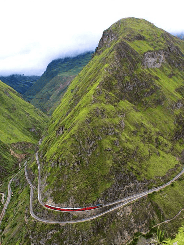 Winding mountain road through lush green hills, scenic driving route, nature travel, aerial view, QuestForDirections.