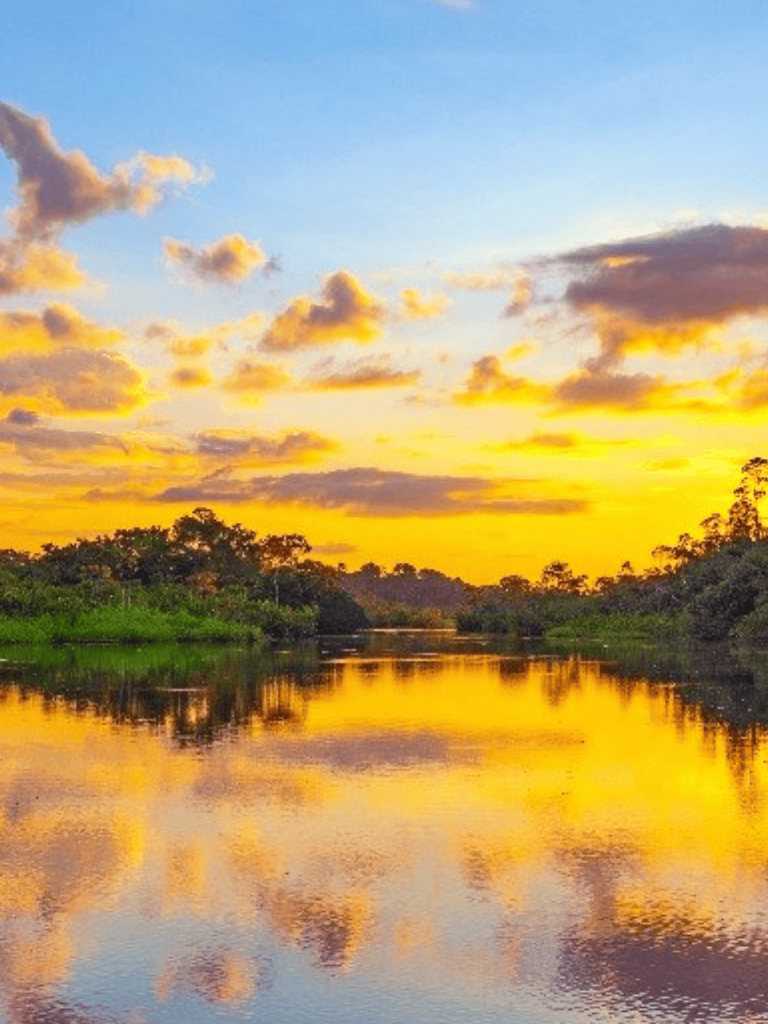 Serene river at sunset with colorful sky, lush trees, perfect for nature and outdoor adventures.