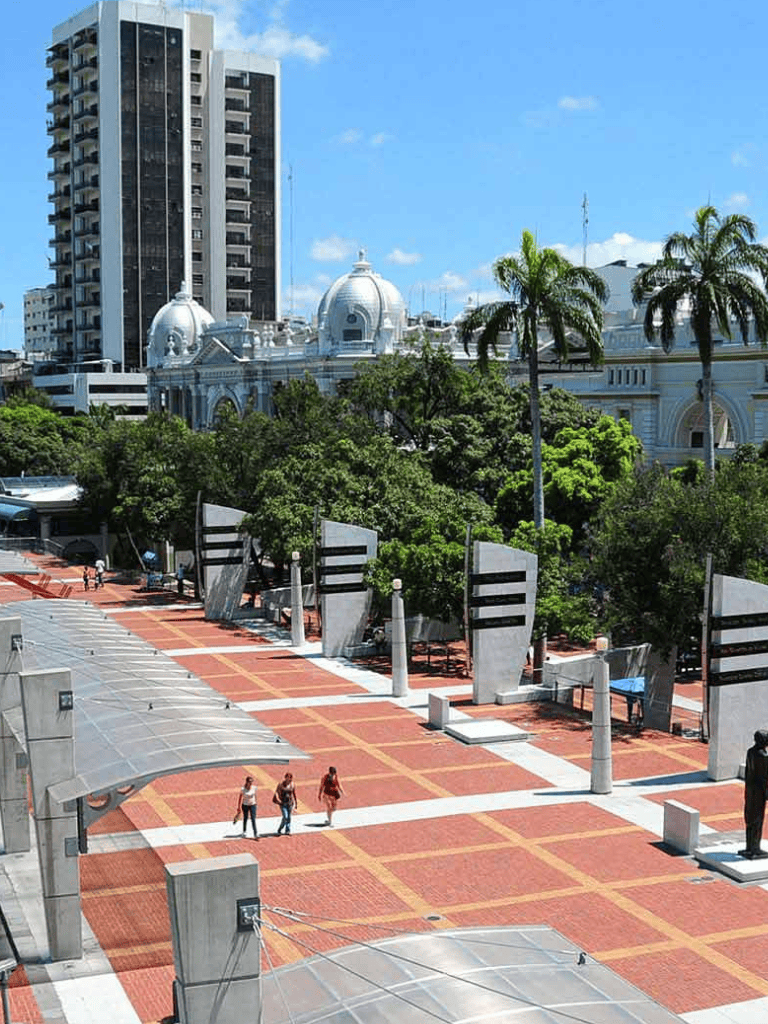 Modern urban cityscape with tall buildings and lush greenery in downtown city park area.