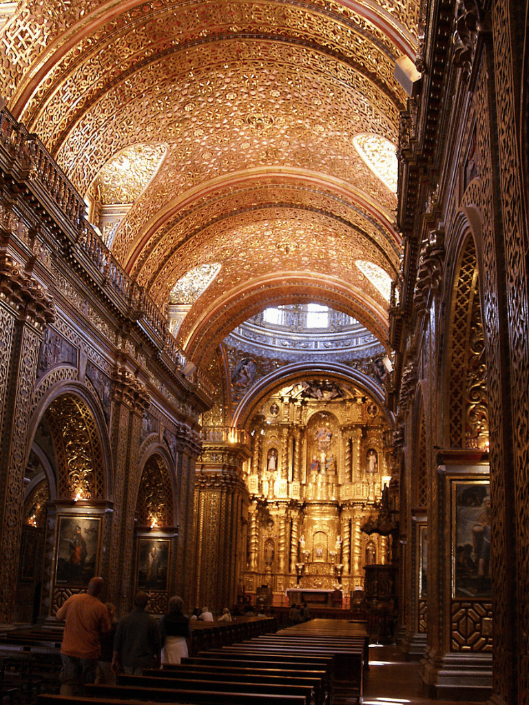 Luxurious ornate church interior with golden details and religious artwork.