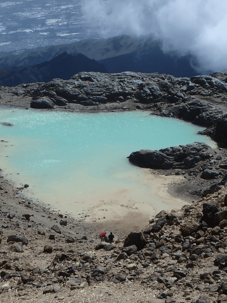 Vulcanic crater lake with turquoise water, rugged terrain, and volcanic landscape, part of QuestForDirections hiking adventure.