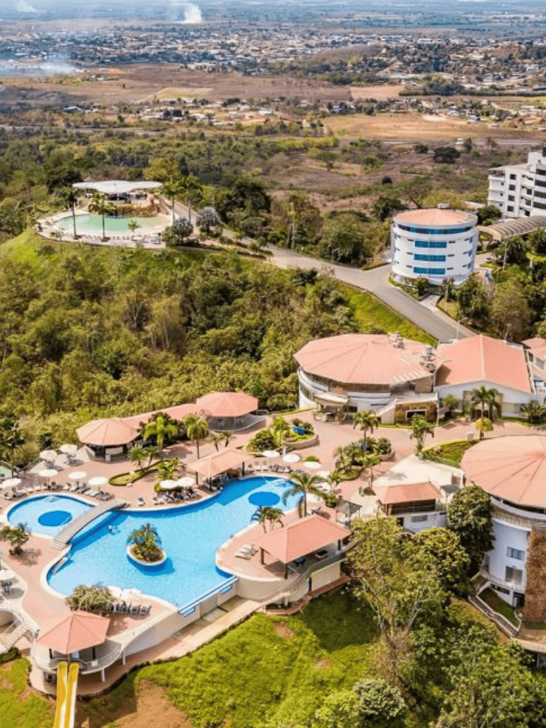 Luxurious residential complex with swimming pools and lush landscaping in a tropical setting.