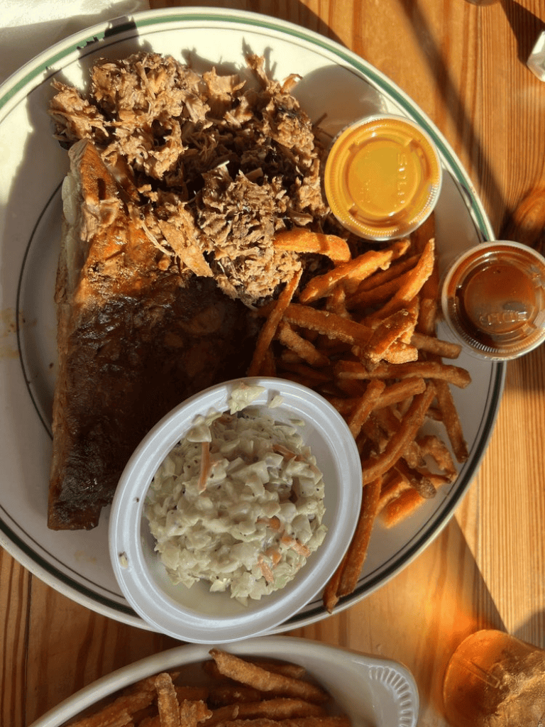 Freshly prepared fried fish with coleslaw, crispy fries, and barbecue sauce at Quest for Directions restaurant.