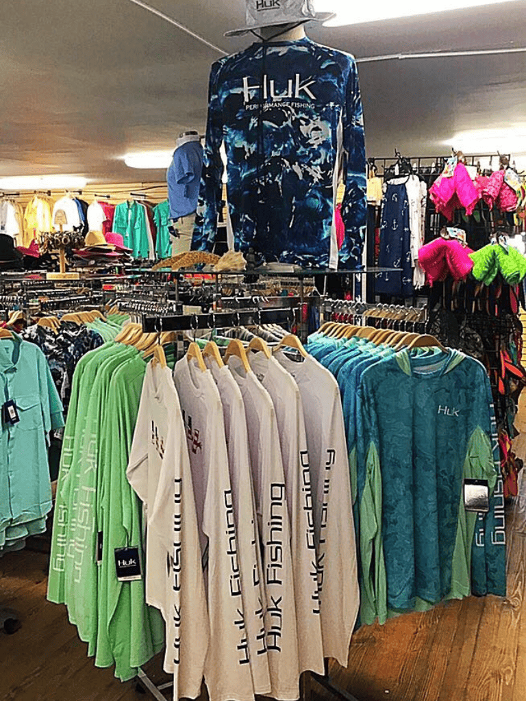 Bright Huk Performance Fishing apparel racks in a retail store display.
