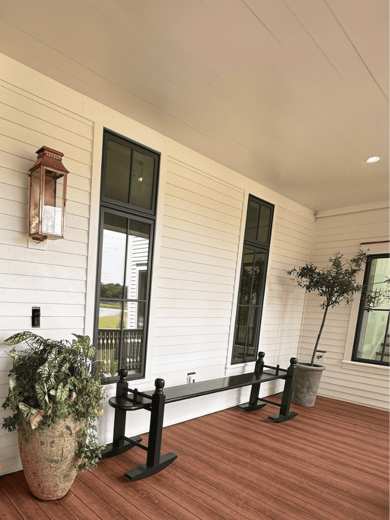 1. Cozy porch with potted plants, wooden floor, and large windows, ideal for outdoor relaxation.