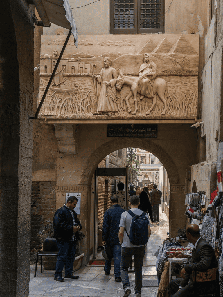 1. Intricate stone relief of biblical scene over archway in ancient city street.