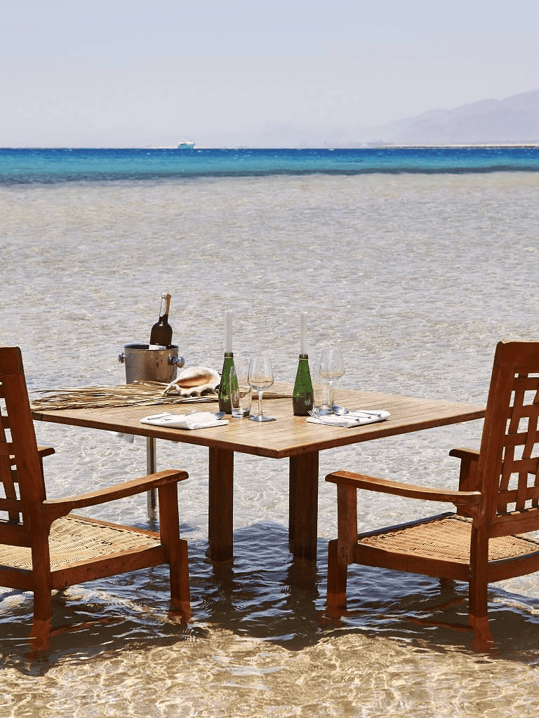 Relaxing beach dining setup with ocean view for ultimate travel and vacation experiences.