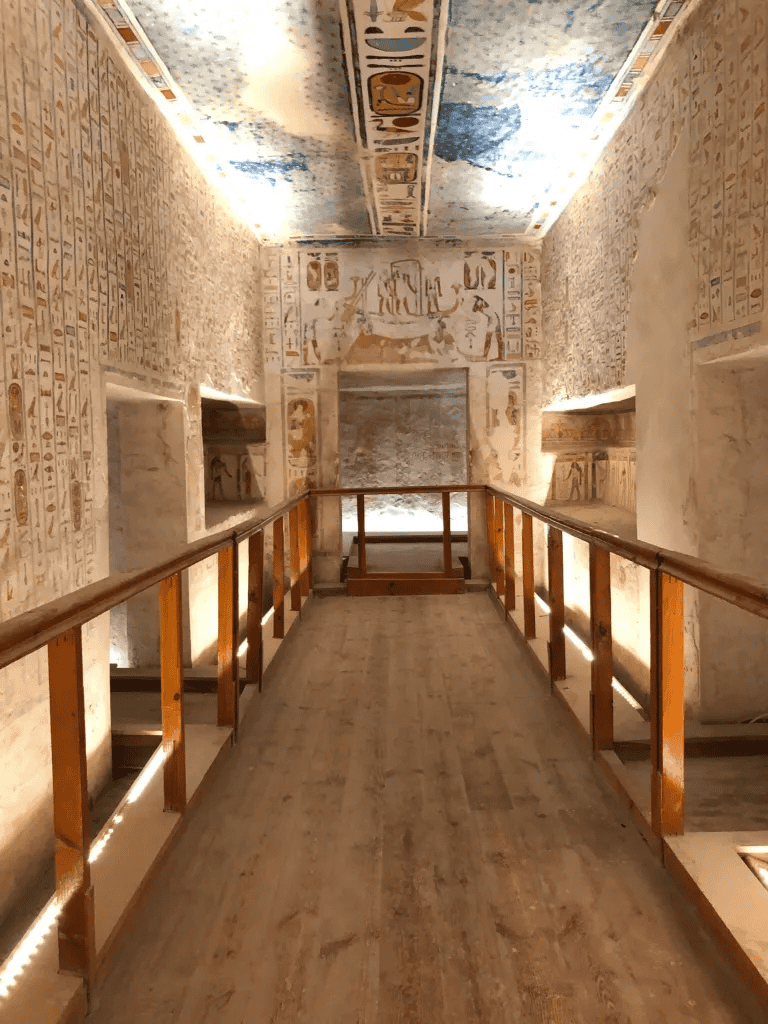 Ancient Egyptian hieroglyphs and artwork inside a historic tomb or temple corridor.