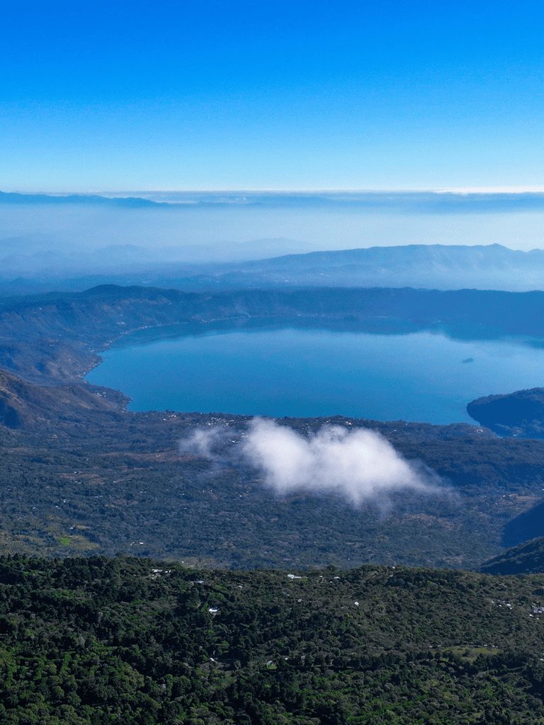 Breathtaking mountain lake view surrounded by lush forests and misty mountains.