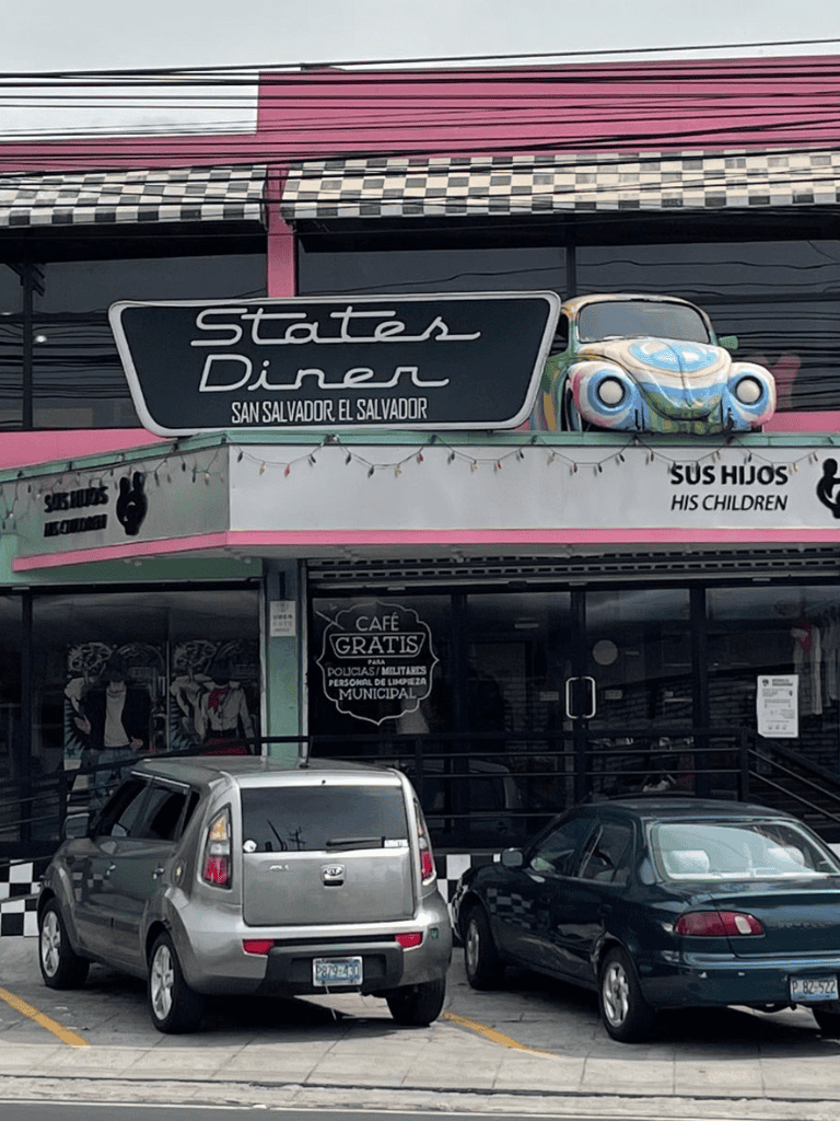 Vintage car-themed diner in San Salvador with retro signage and cars parked outside, perfect for classic car lovers and nightlife.