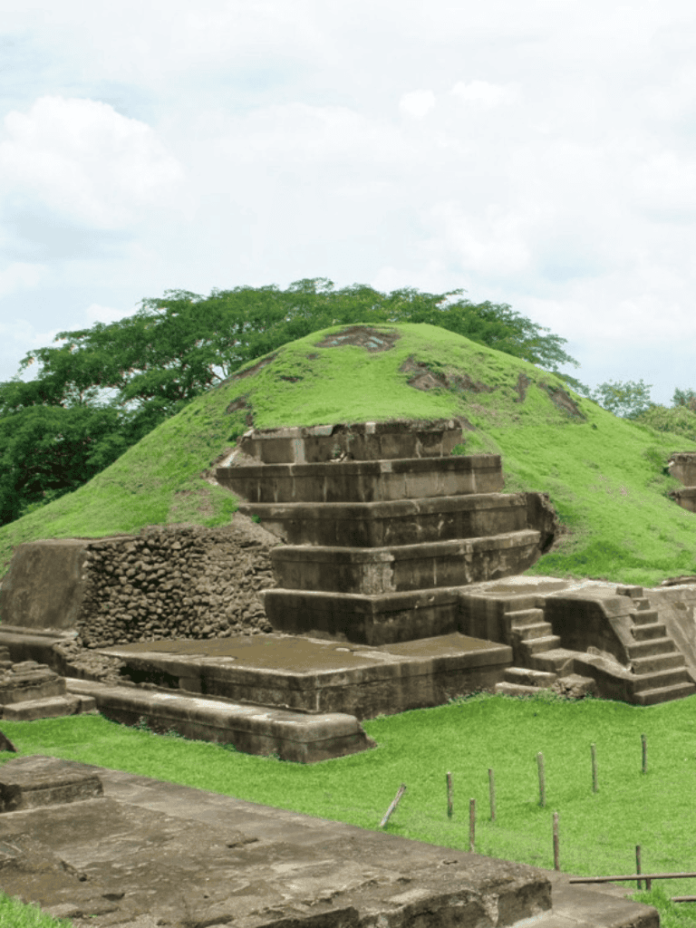 Ancient step pyramid at Quest for Directions archaeological site in lush green landscape.