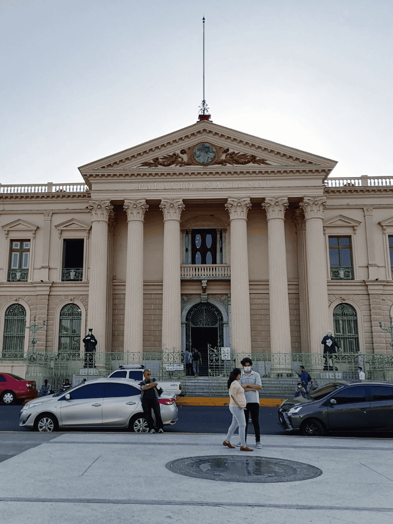 Palacio Nacional in Mexico City with classical architecture and people outside.
