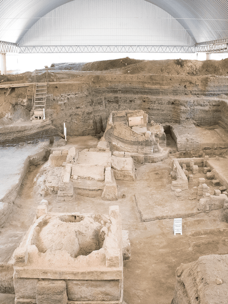 Ancient archaeological excavation site inside a museum, revealing historical ruins and artifacts.