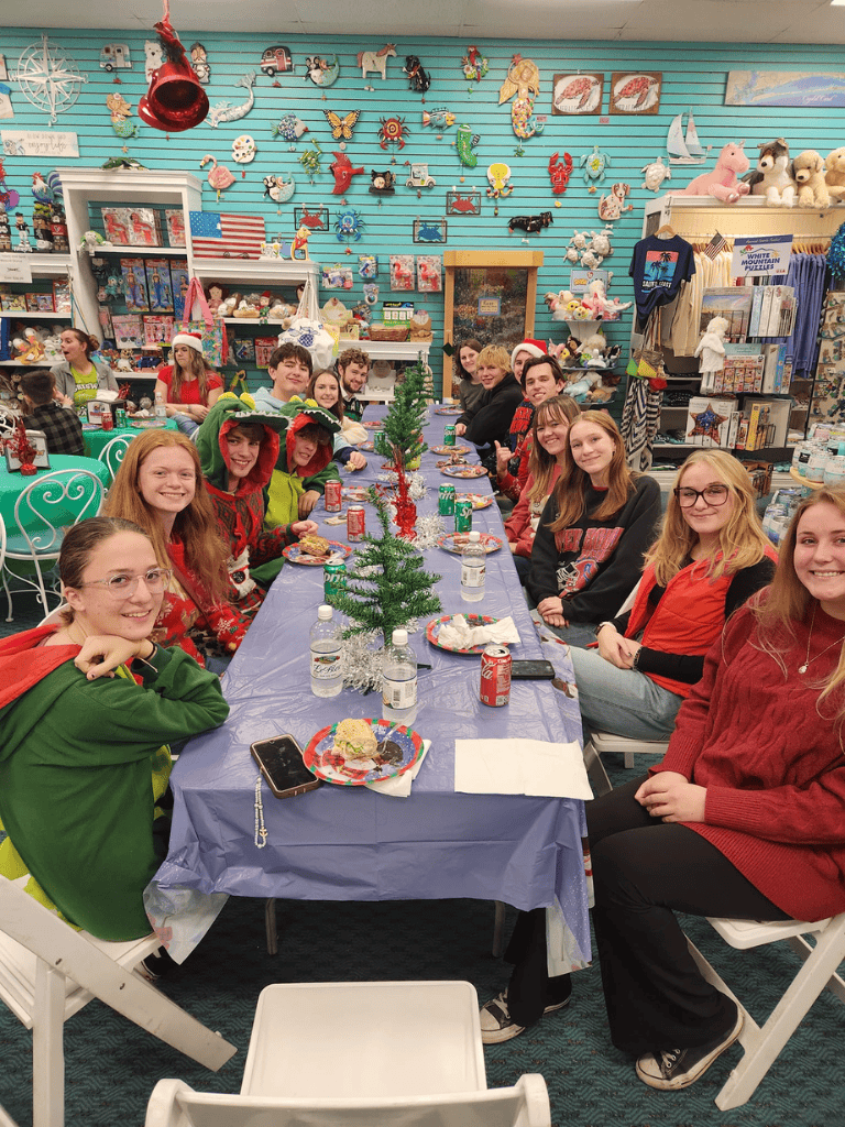 Christmas party with kids and teens celebrating holiday season at Toy Store, festive decorations, snacks, and gifts, joyful atmosphere.
