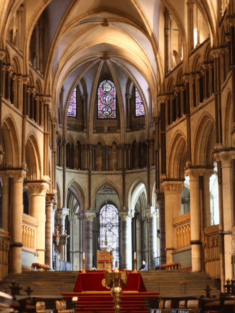 Intricate Gothic cathedral interior with stained glass windows and vaulted ceilings.