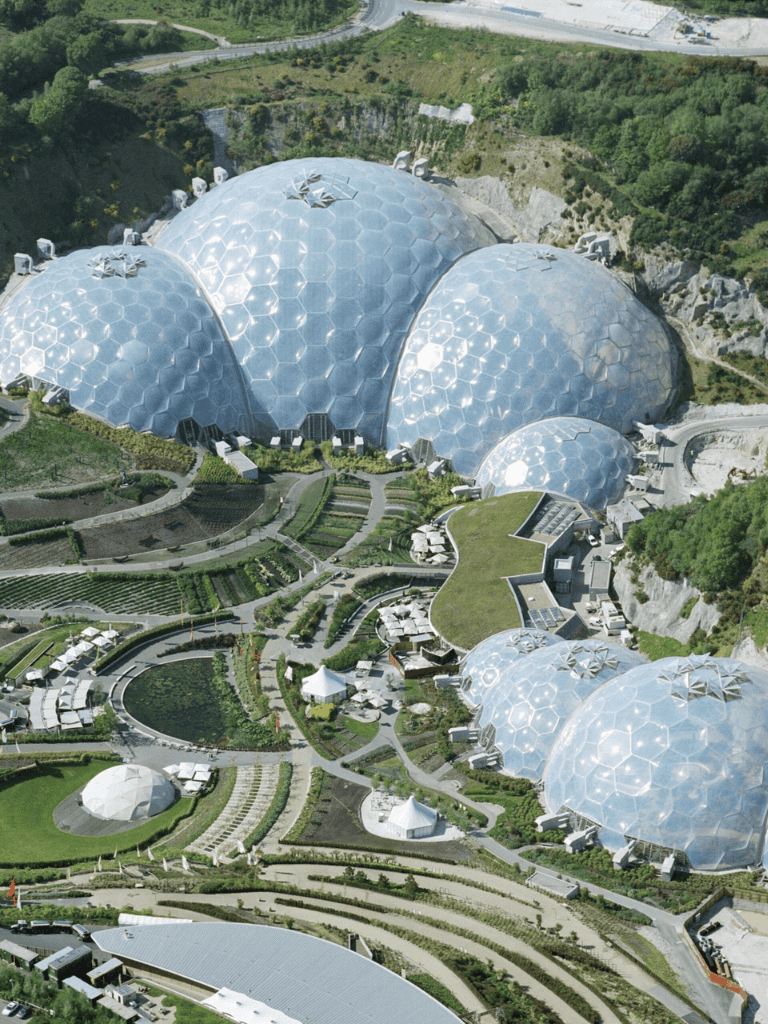 Junior, futuristic geodesic domes surrounded by lush greenery and gardens at Quest for Directions.