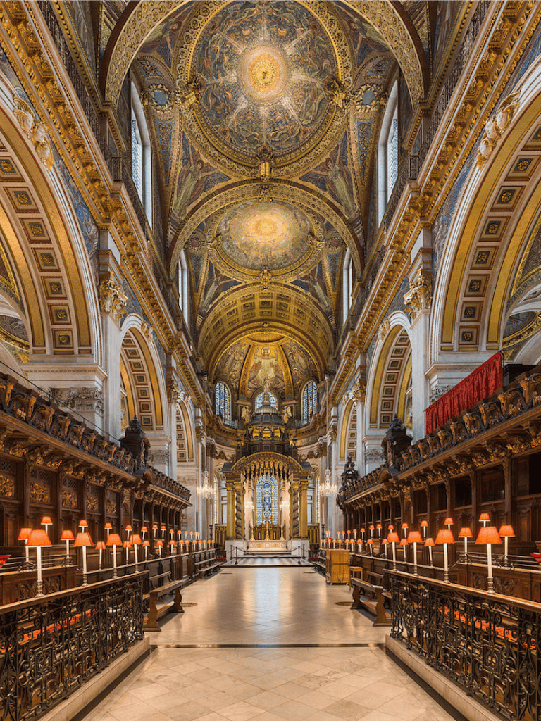 Ornate cathedral interior with golden ceiling, stained glass windows, and intricate woodwork, representing historic architecture.