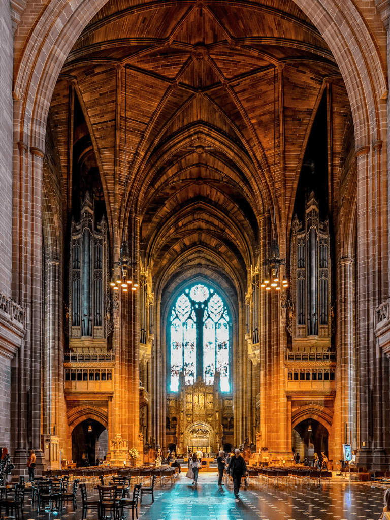 Majestic Gothic cathedral interior with towering arches and intricate stained glass windows.