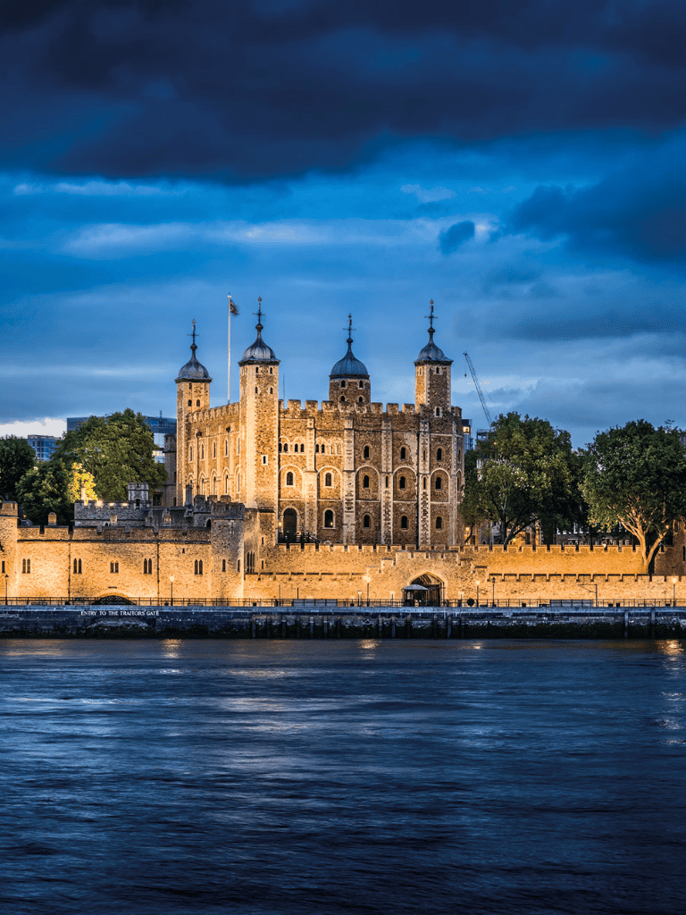 Medieval castle by Thames River at dusk, London attractions, historical landmarks.