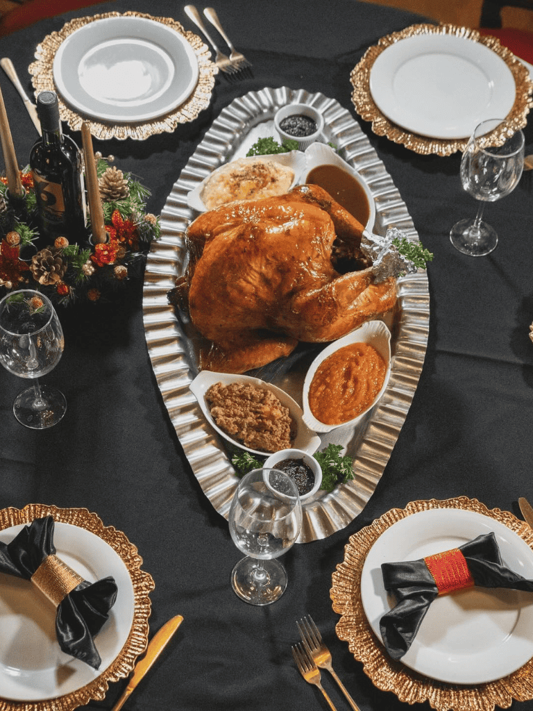 Roast turkey with sides on a festive holiday table, elegant dinner setting, holiday meal celebration.