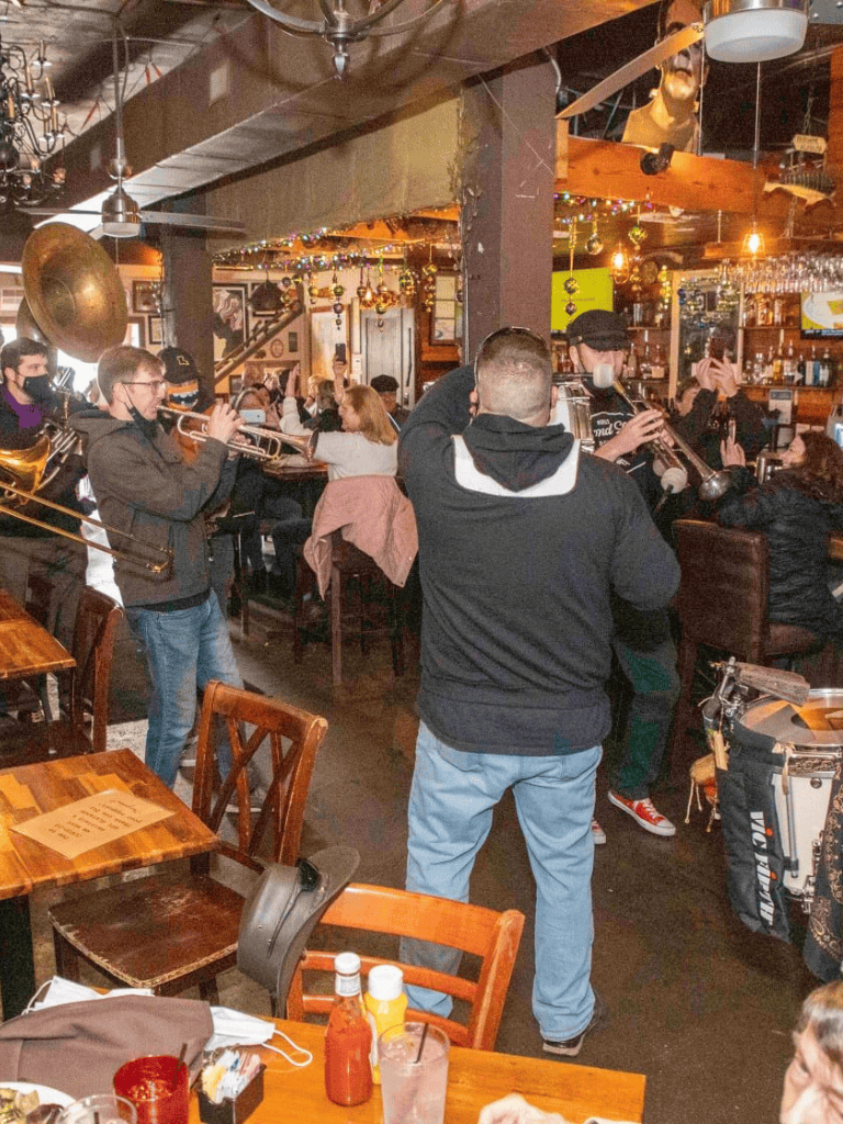 Live jazz band performing at a lively restaurant with patrons enjoying music and drinks.