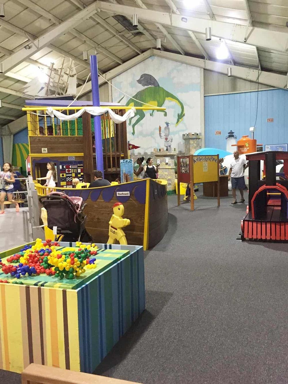 Colorful indoor playground with pirate ship, climbing structures, and children playing. Perfect for kids' entertainment at Quest for Directions.