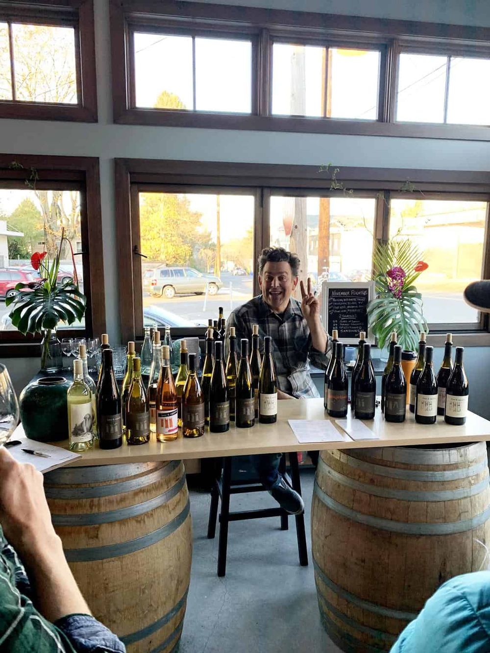 Vine tasting event at Quest for Directions winery with a smiling man making a peace sign.