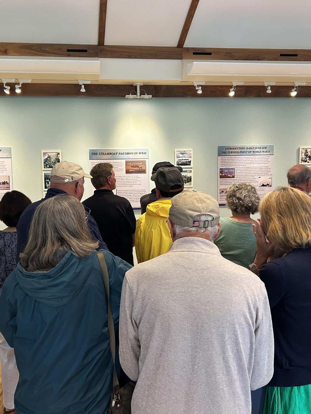 1. Visitors viewing WWII history exhibit at QuestForDirections museum.