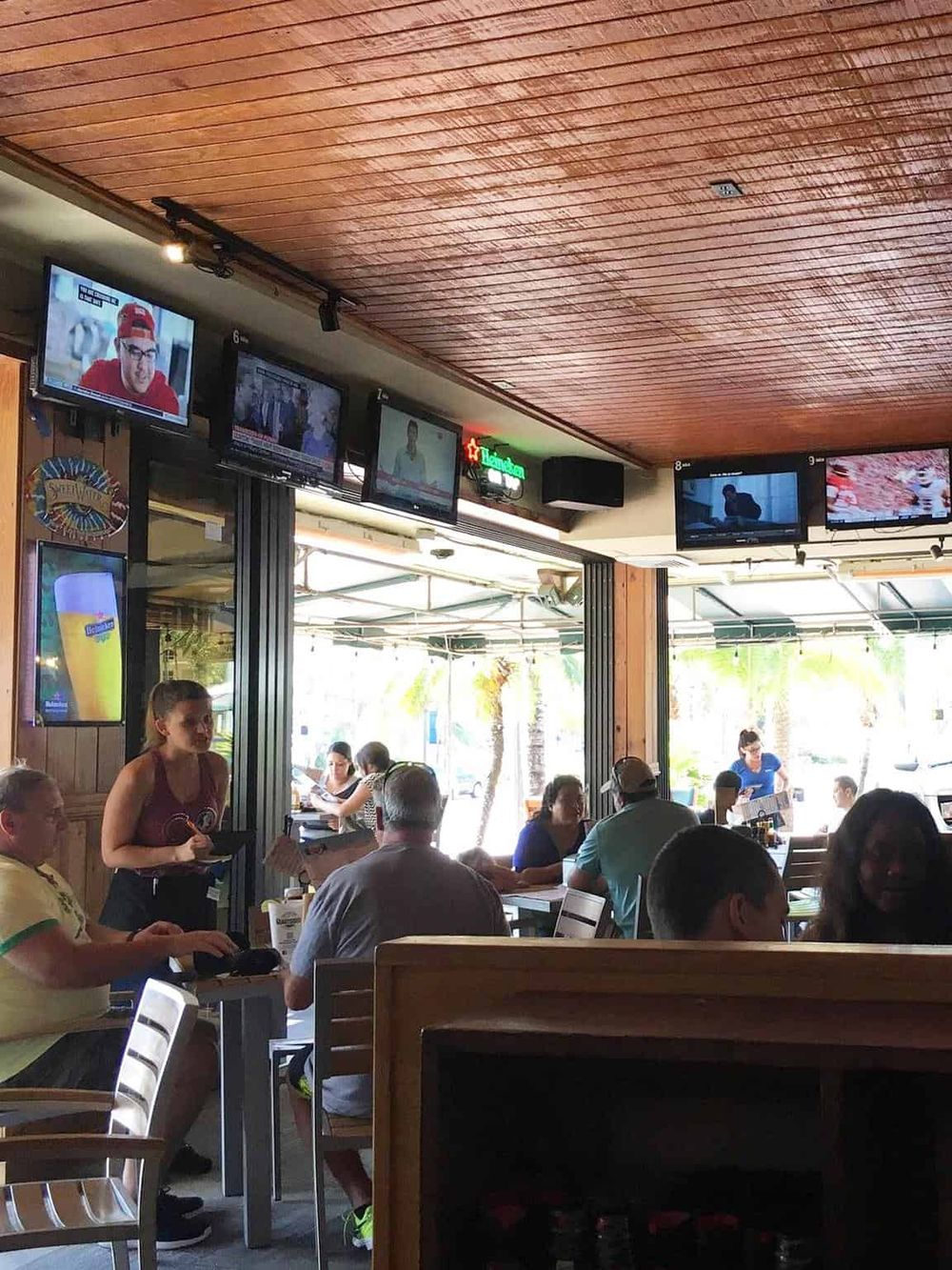1. Modern sports bar with multiple TV screens showing live games and news.