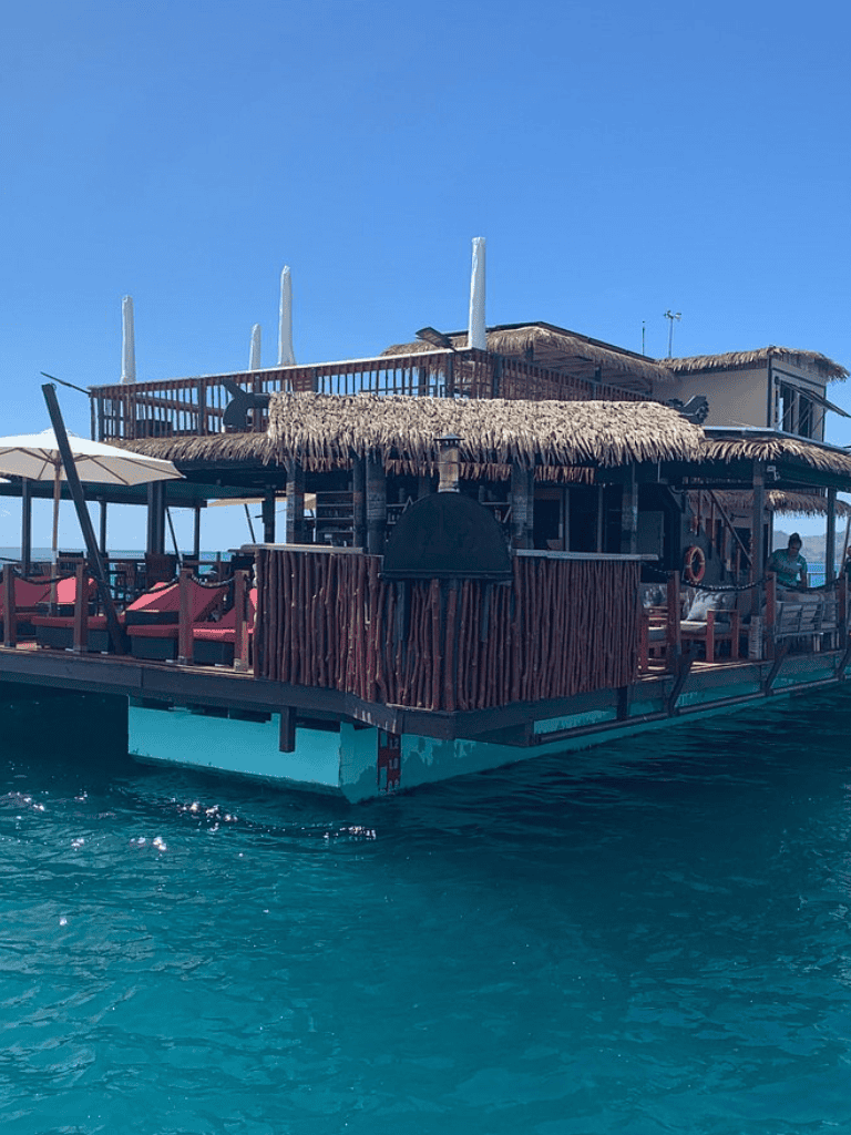 Vintage floating tiki bar experience with tropical decor and ocean views.