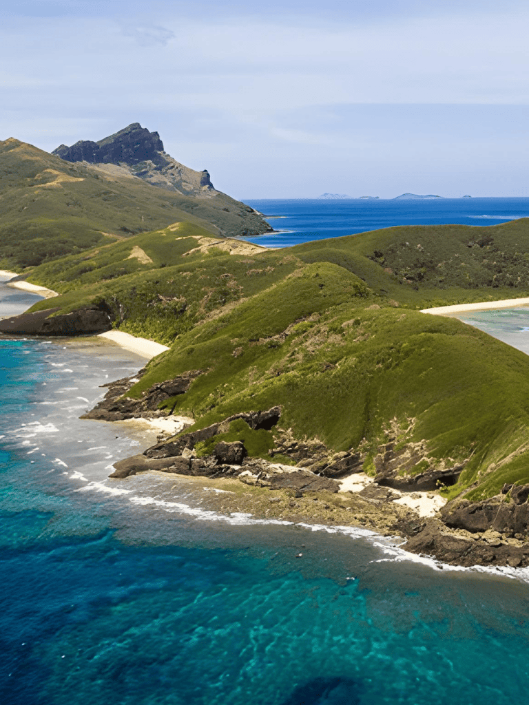 Breathtaking coastal landscape with lush green hills and turquoise ocean waters.