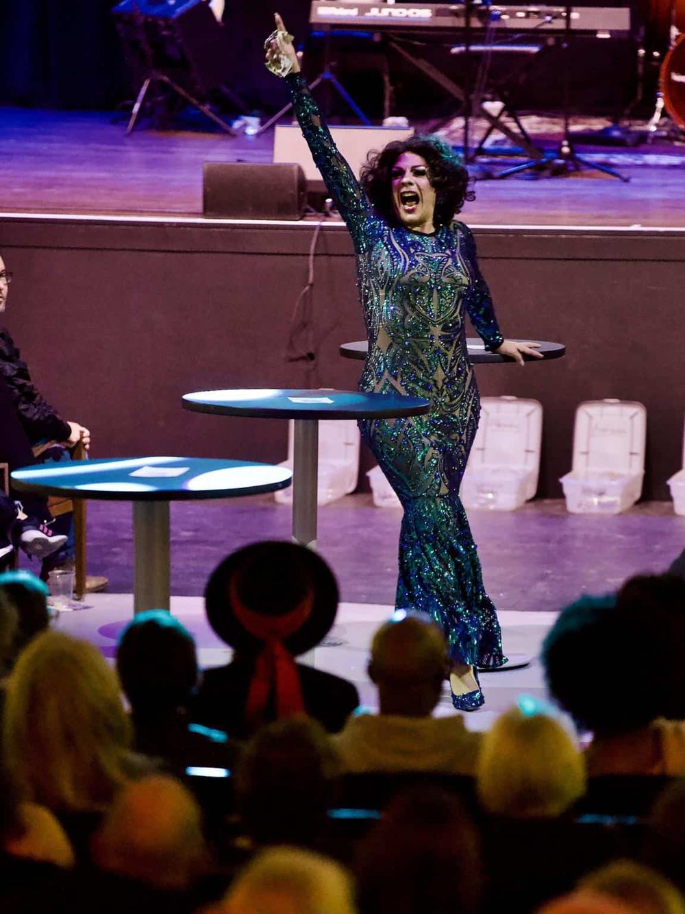 Sequined performer captivating audience at Quest For Directions event, lively entertainment and dynamic stage presence.