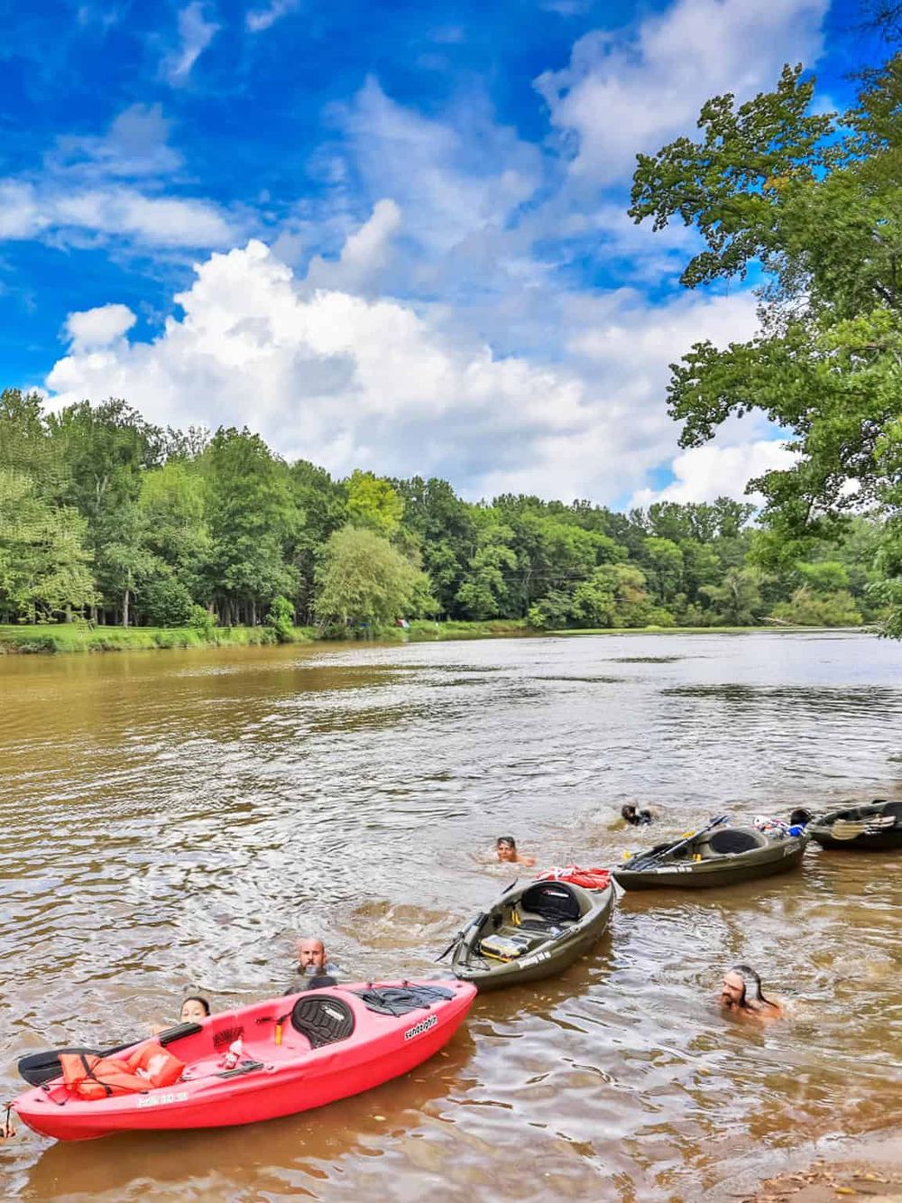 Kayaking on a scenic river surrounded by lush green trees, ideal for outdoor adventure and nature exploration.