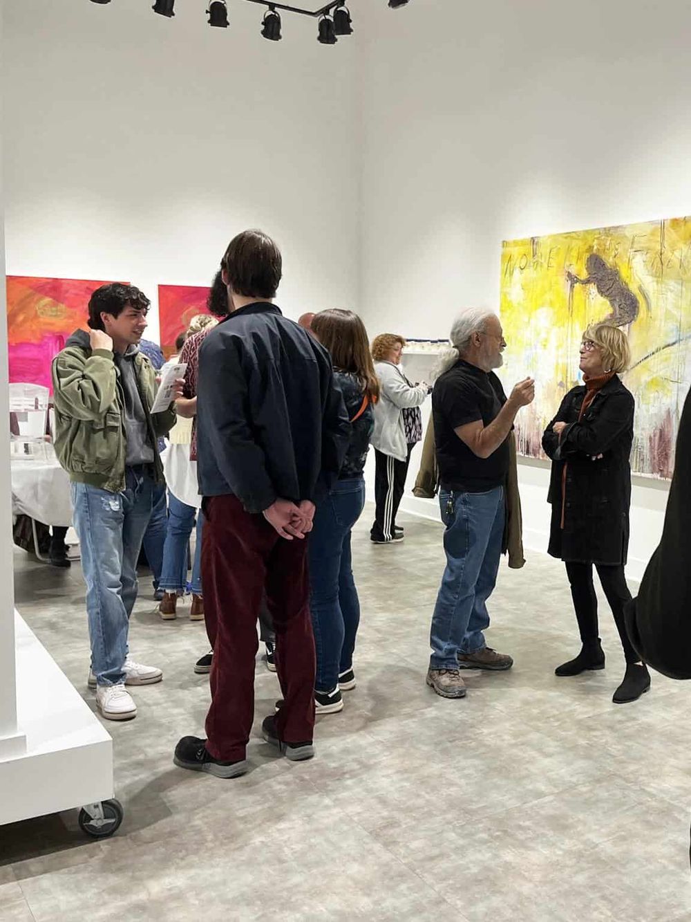 1. Art gallery visitors engaging with contemporary paintings at QuestForDirections.