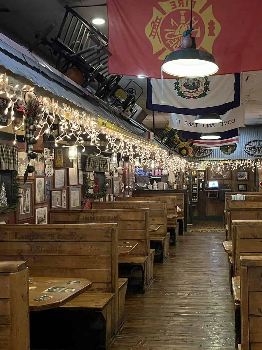 Festive restaurant interior with wooden booths, holiday string lights, and patriotic flags for a cozy dining experience.