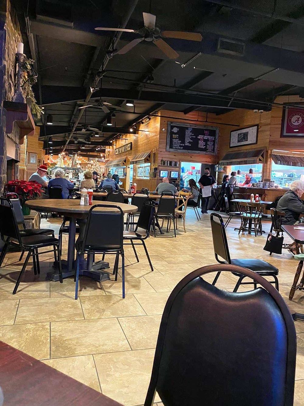 Cozy restaurant interior with wooden accents, TVs, and diners enjoying meals, perfect for family and friends.