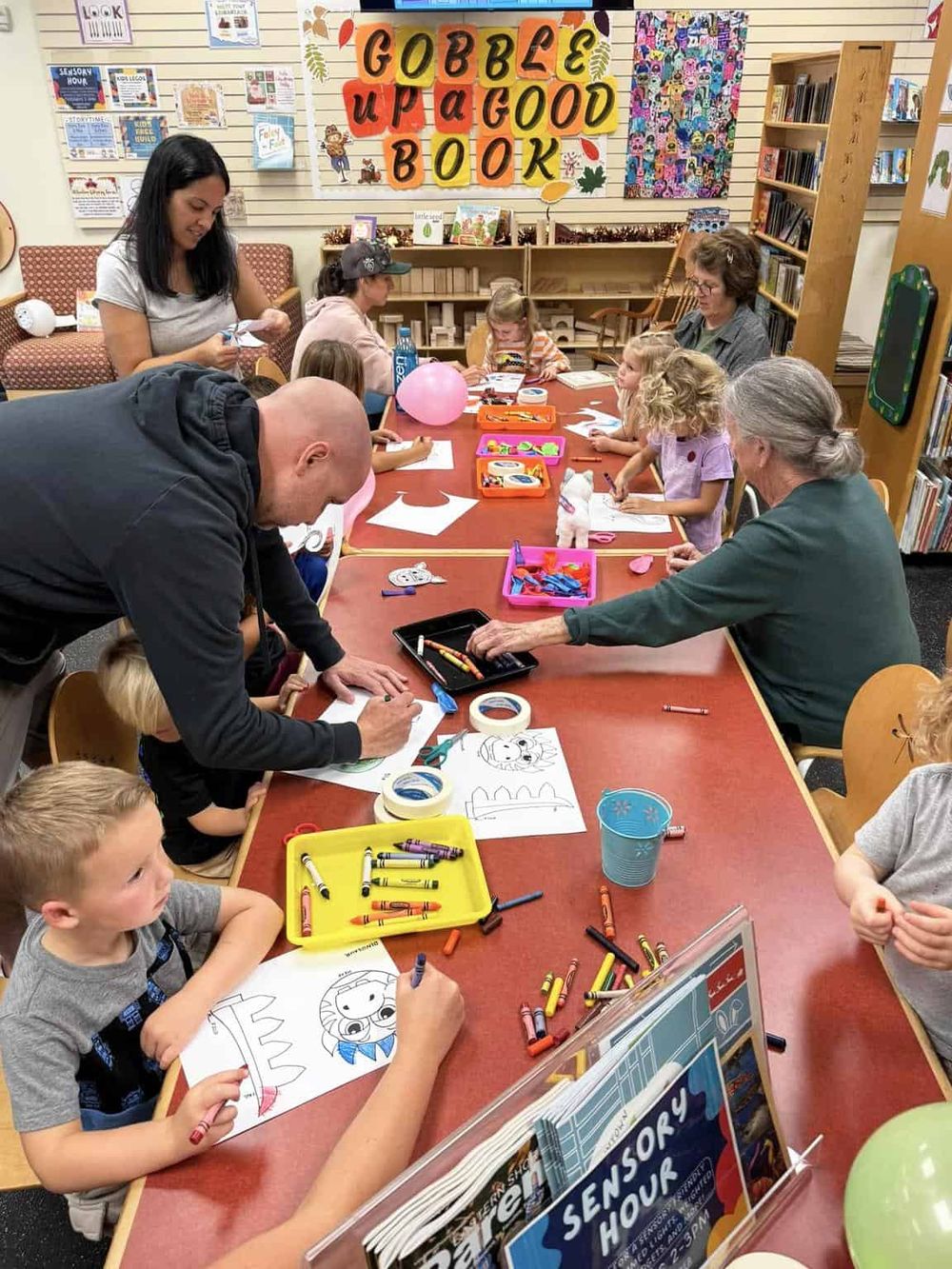 Colorful children’s craft activity at library storytime with parents and caregivers.