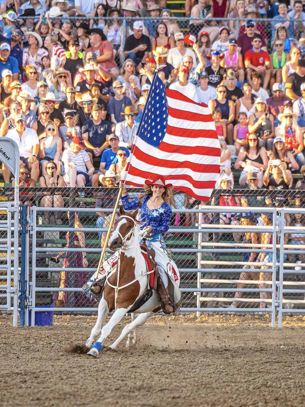 American flag rider at patriotic rodeo event with large audience, celebrating American culture and traditions.