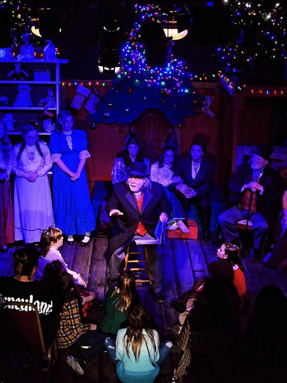 Illuminated Christmas scene featuring a theatrical performance at QuestForDirections holiday event.