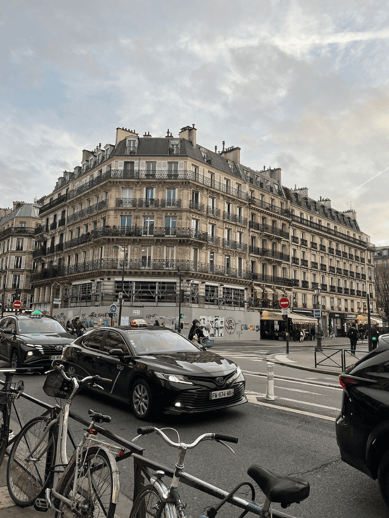 Charming Parisian street view featuring classic architecture and busy city traffic.