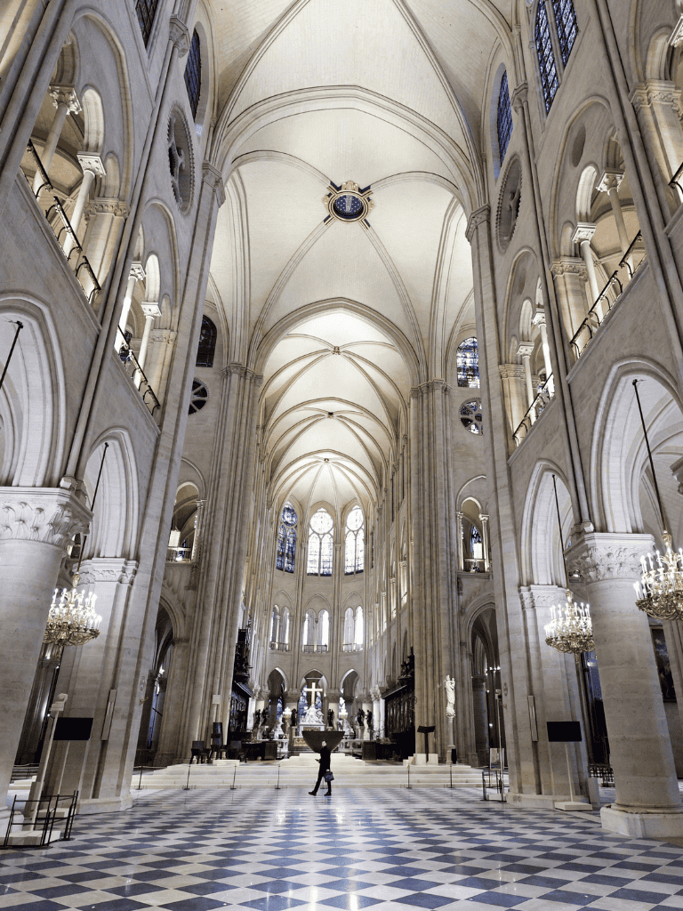 Ornate cathedral interior with soaring vaulted ceilings and elegant stained glass windows.