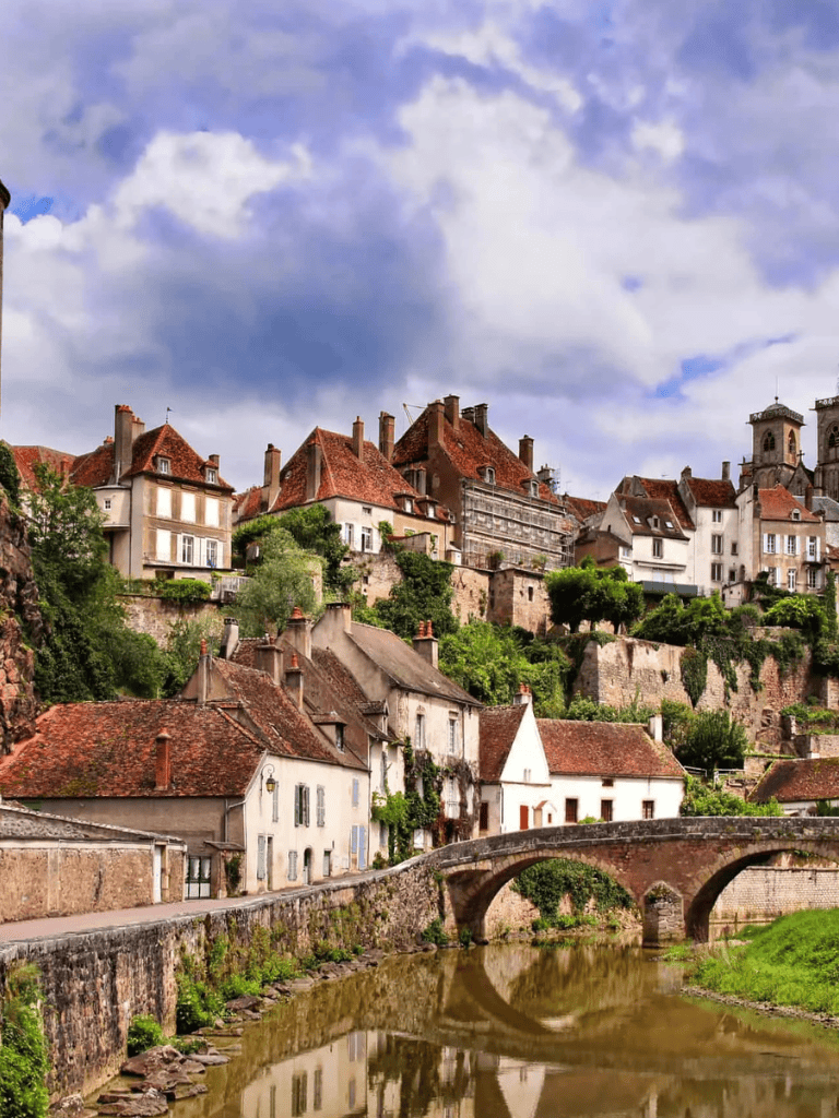 Charming European hillside town with historic architecture and river view, showcasing outdoor beauty and scenic landscapes.