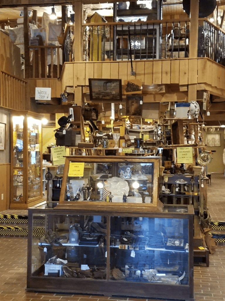 Antique store interior with wooden display cases and vintage items for sale.