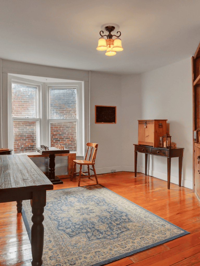 Cozy room with wooden furniture, large window, and classic rug, ideal for home decor inspiration.