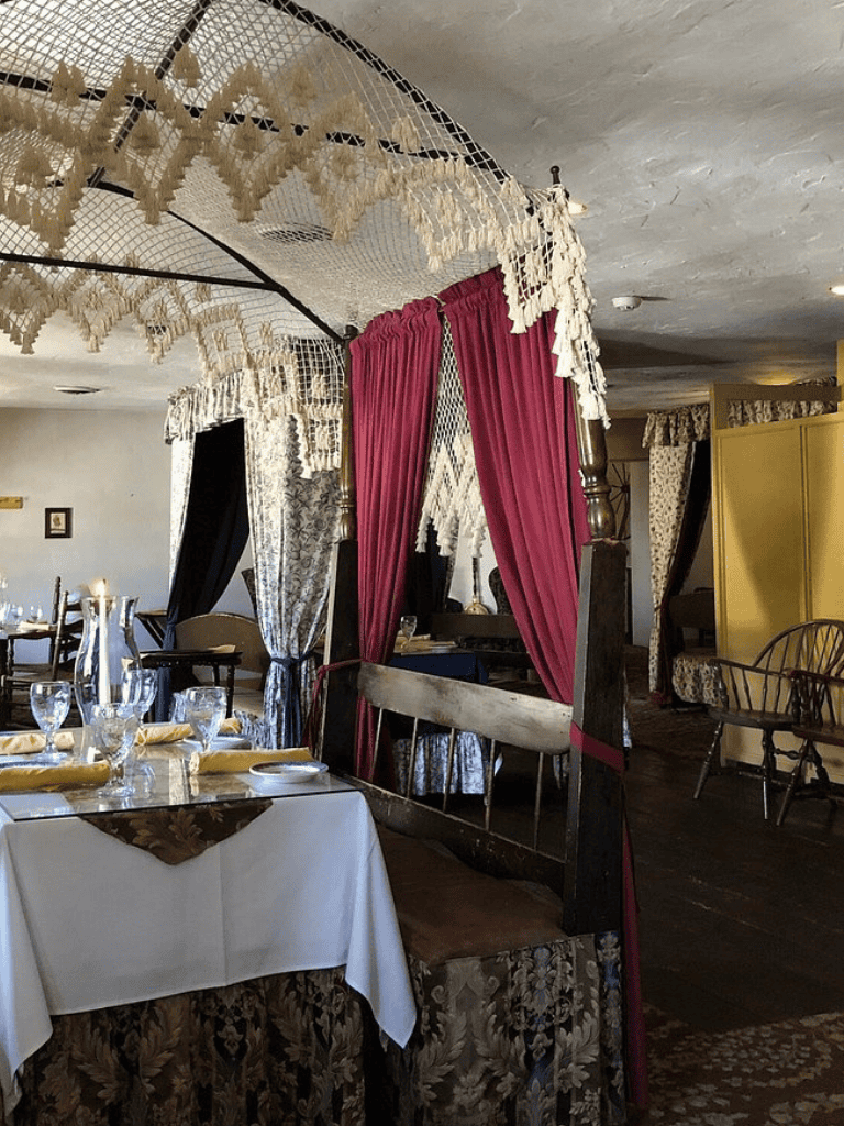 Cozy vintage restaurant interior with draped curtains and elegant dining setup.